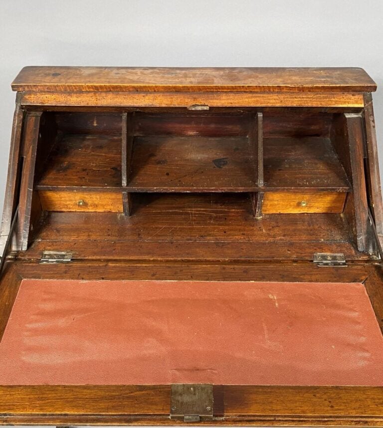 Bureau de pente en noyer mouluré et sculpté à décor de corbeille fleurie suspen…
