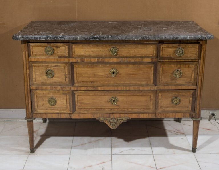 Commode en bois de placage et encadrements marqueté à trois rangs de tiroirs. D…