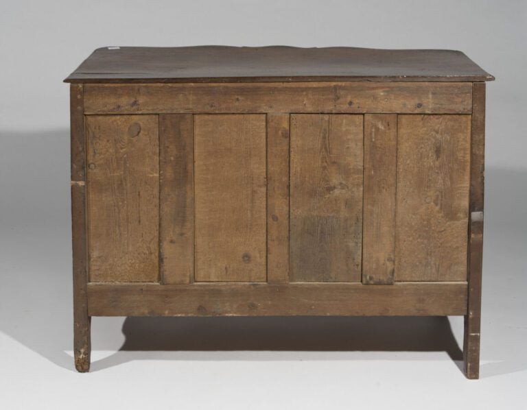 Commode en bois naturel mouluré et sculpté de forme rectangulaire. Elle présent…