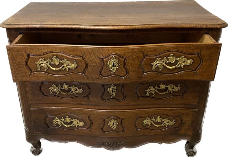Commode en noyer mouluré à façade légèrement galbée ouvrant à trois tiroirs en…