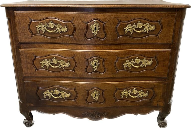 Commode en noyer mouluré à façade légèrement galbée ouvrant à trois tiroirs en…