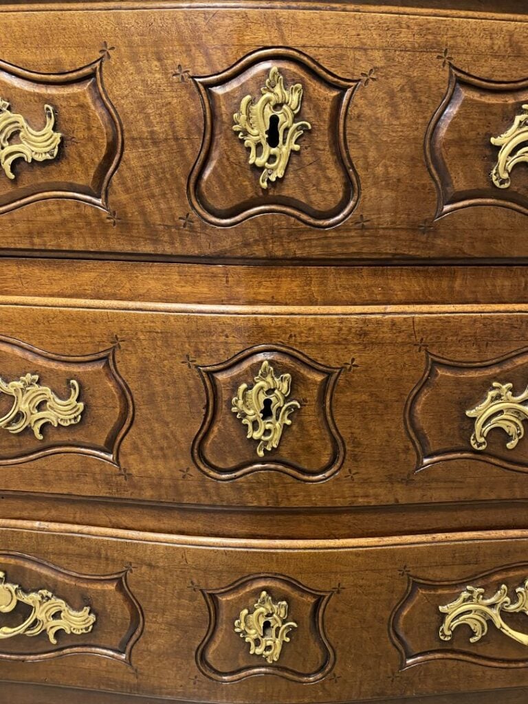 Commode en noyer mouluré à façade légèrement galbée ouvrant à trois tiroirs en…