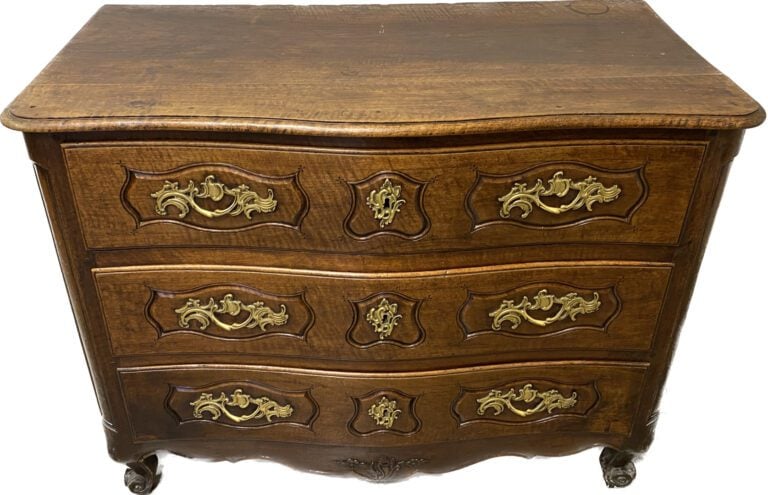 Commode en noyer mouluré à façade légèrement galbée ouvrant à trois tiroirs en…