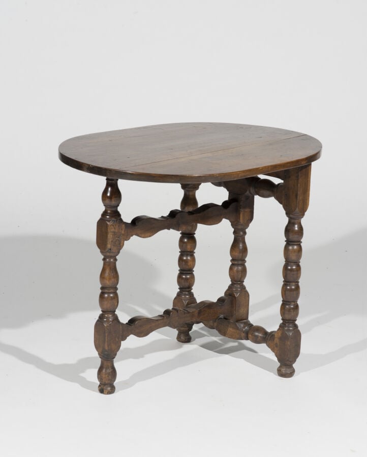 En semble de quatre tables en bois naturel comprenant : - Une table ovale à vol…