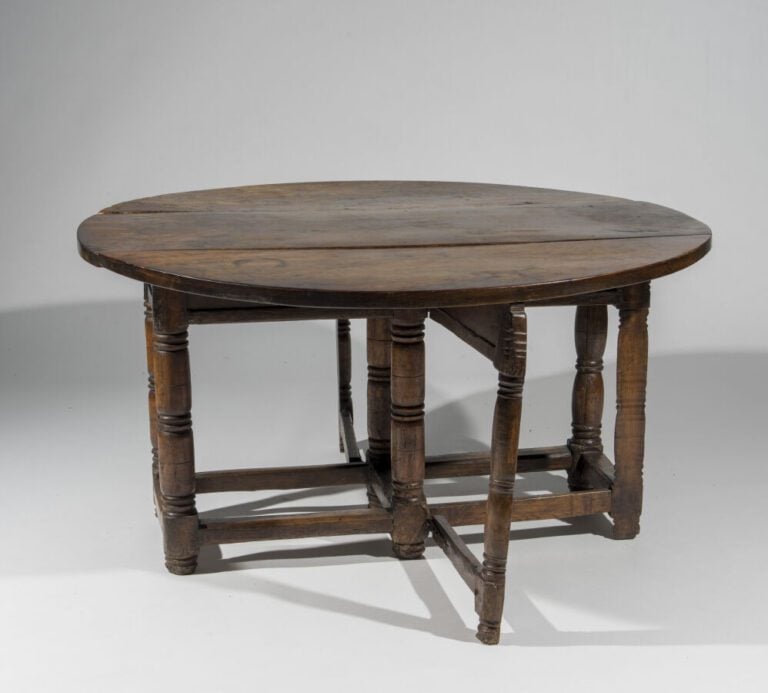 En semble de quatre tables en bois naturel comprenant : - Une table ovale à vol…