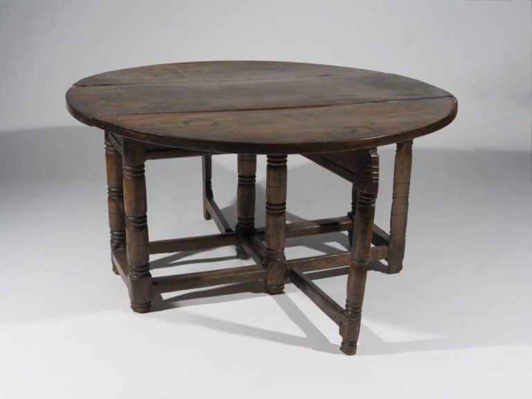 En semble de quatre tables en bois naturel comprenant : - Une table ovale à vol…