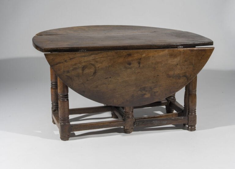 En semble de quatre tables en bois naturel comprenant : - Une table ovale à vol…
