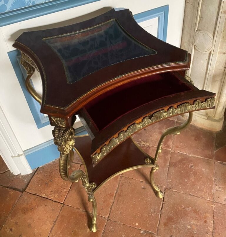 Guéridon formant vitrine en acajou et métal doré ouvrant par un tiroir ; il rep…