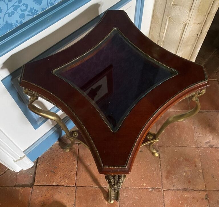 Guéridon formant vitrine en acajou et métal doré ouvrant par un tiroir ; il rep…