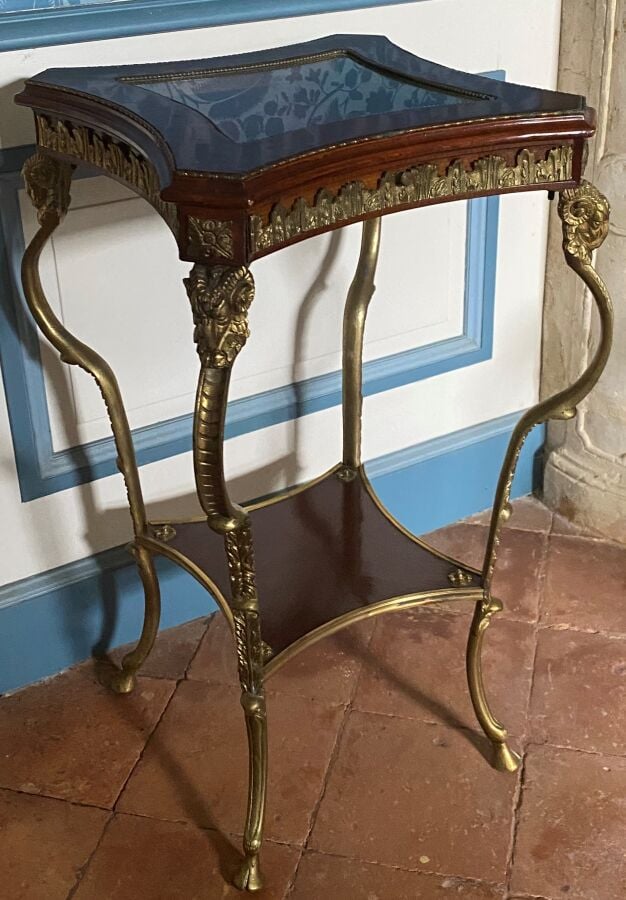 Guéridon formant vitrine en acajou et métal doré ouvrant par un tiroir ; il rep…