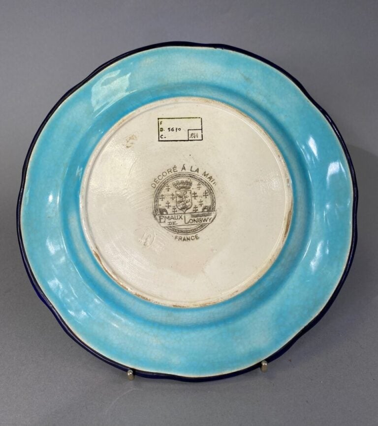 LONGWY - Plat circulaire en faïence à décor floral en émaux polychromes sur fon…