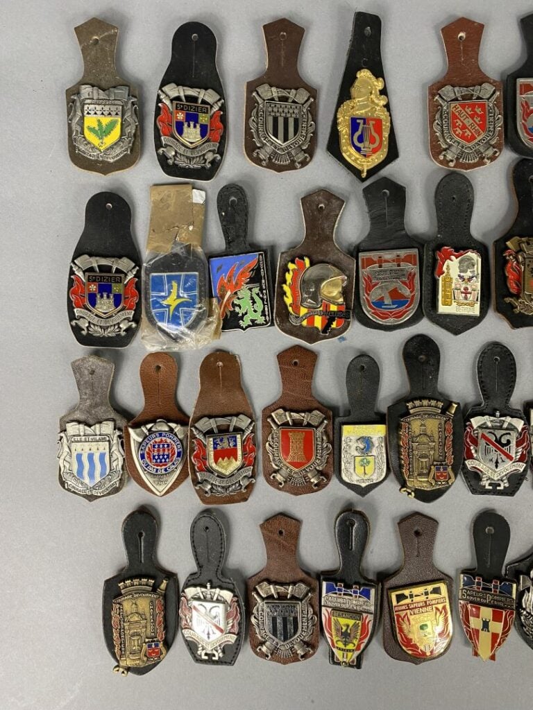 Lot comprenant divers insignes métalliques et pucelles Sapeurs-pompiers, Police…