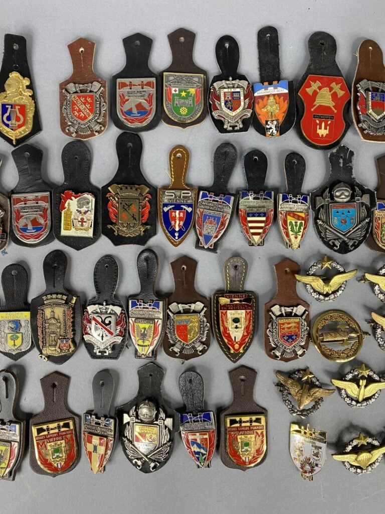 Lot comprenant divers insignes métalliques et pucelles Sapeurs-pompiers, Police…