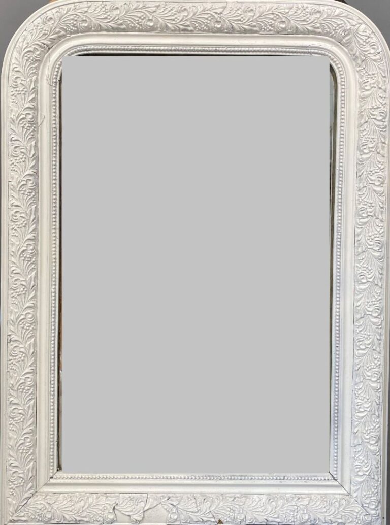 Miroir en bois et composition relaqué blanc, cintré en partie haute, à décor de…