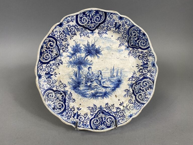 Paire d'assiettes à bord contourné en faïence à décor en camaïeu bleu de scènes…