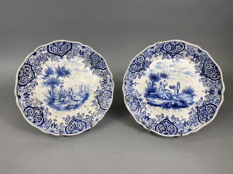 Paire d'assiettes à bord contourné en faïence à décor en camaïeu bleu de scènes…