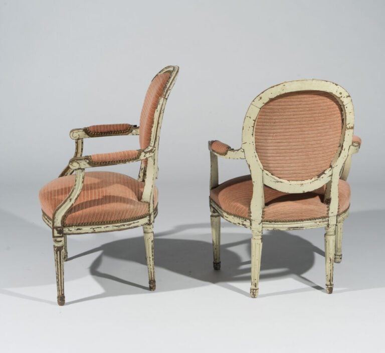Paire de fauteuils à dossier médaillon en bois mouluré relaqué blanc ; piétemen…