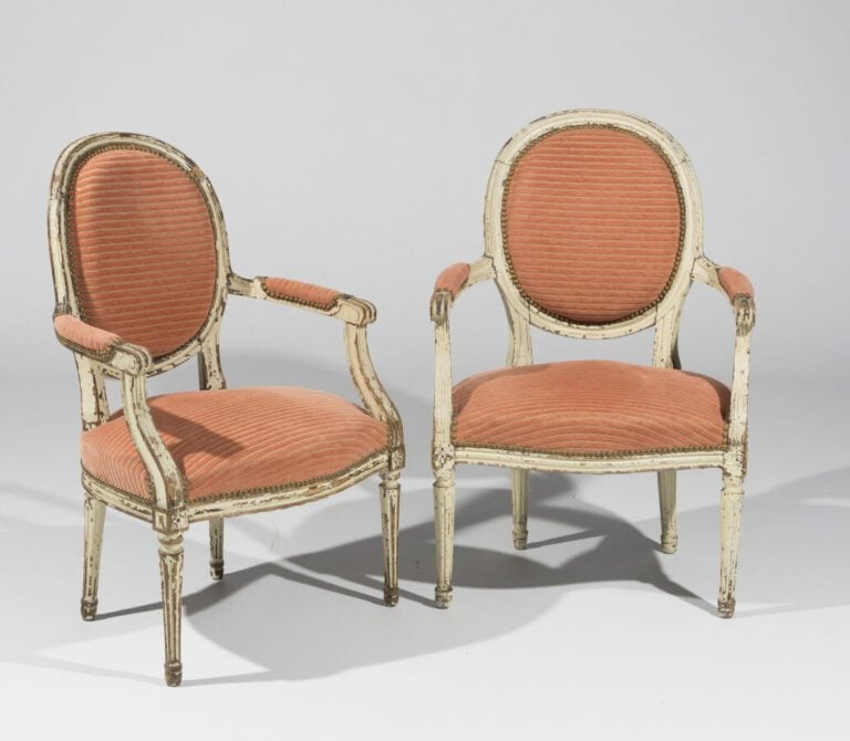Paire de fauteuils à dossier médaillon en bois mouluré relaqué blanc ; piétemen…