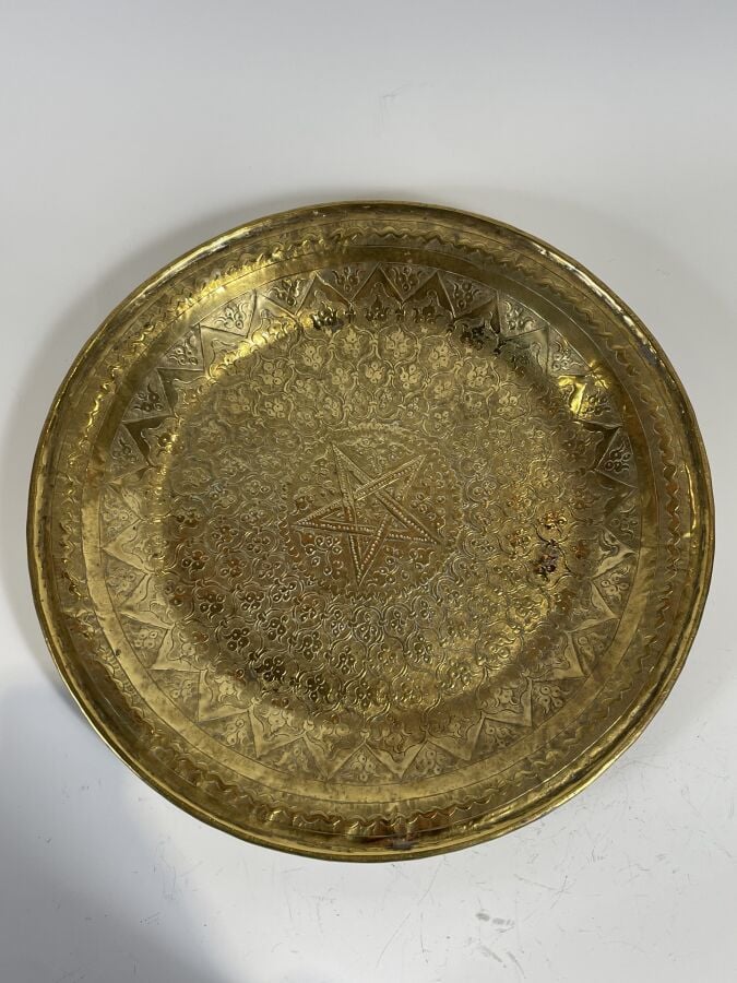 Plat rond en cuivre à décor au repoussé de fleurettes dans des réserves. Diamèt…