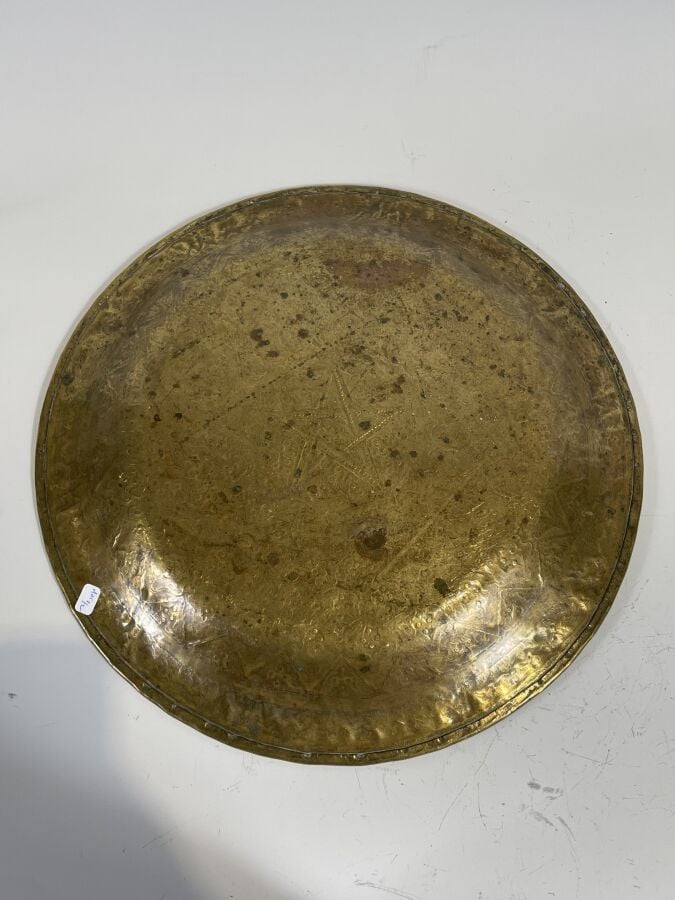 Plat rond en cuivre à décor au repoussé de fleurettes dans des réserves. Diamèt…