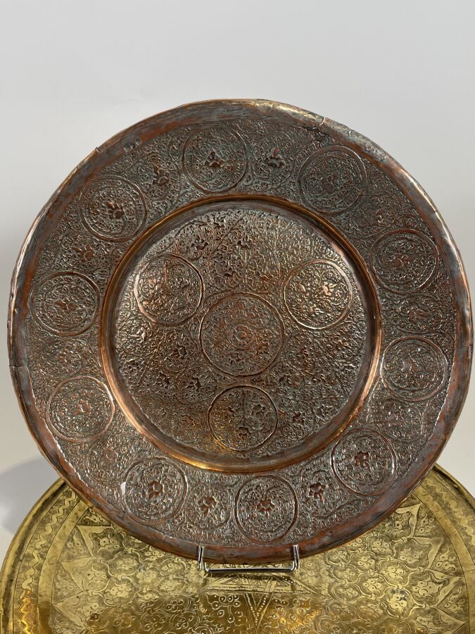 Plat rond en cuivre à décor au repoussé de fleurettes dans des réserves. Diamèt…
