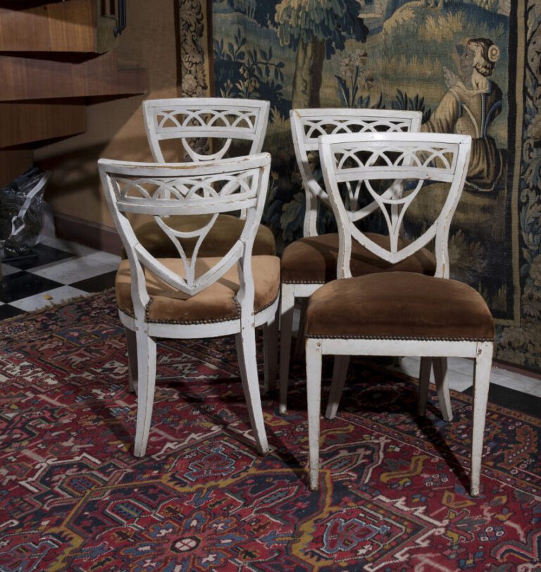 Suite de quatre chaises à dossier écusson ajouré en bois laqué blanc. XIXème si…
