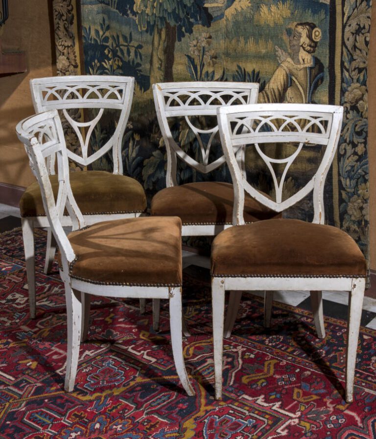 Suite de quatre chaises à dossier écusson ajouré en bois laqué blanc. XIXème si…