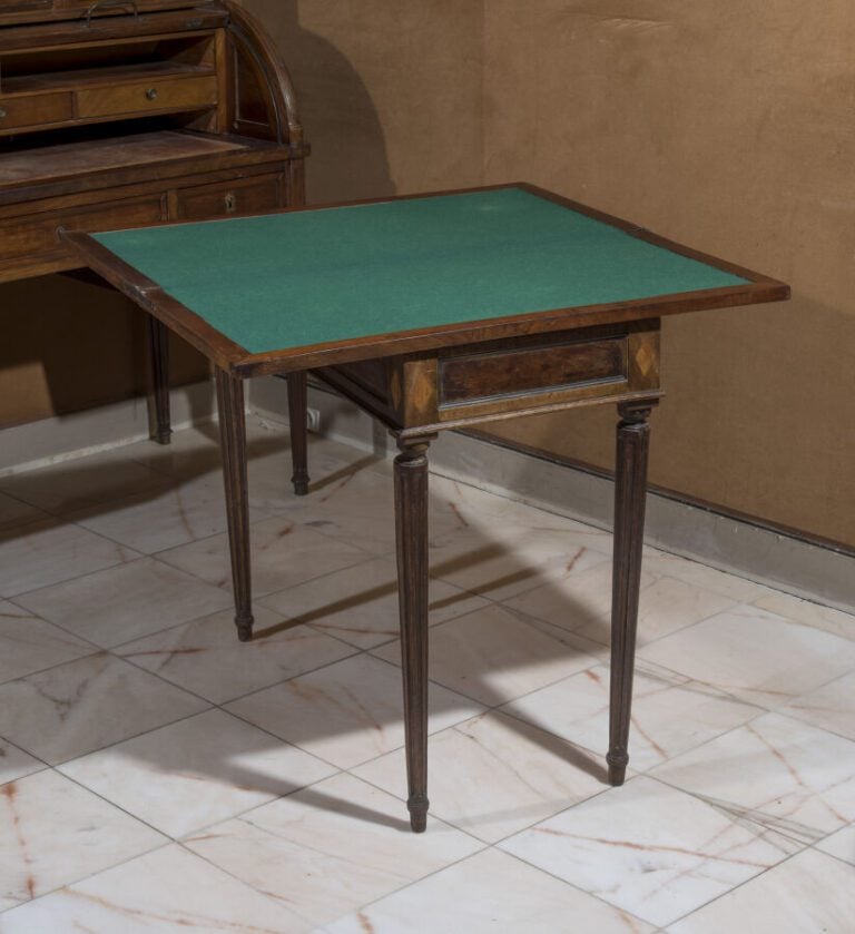 Table à jeux à plateau portefeuille en bois teinté et mouluré de laiton. Pieds…