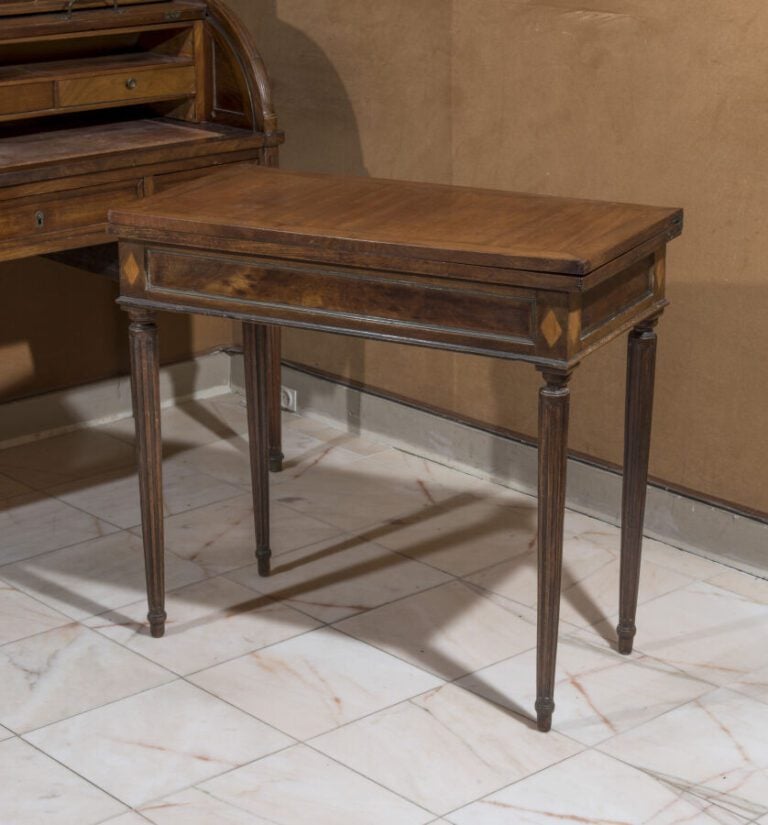 Table à jeux à plateau portefeuille en bois teinté et mouluré de laiton. Pieds…