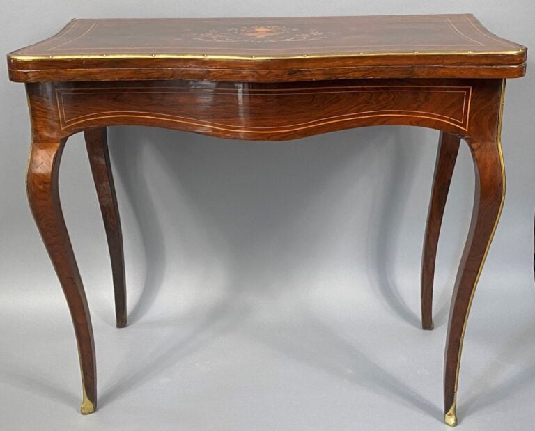 Table à jeux de forme mouvementée en placage de palissandre à décor marqueté de…