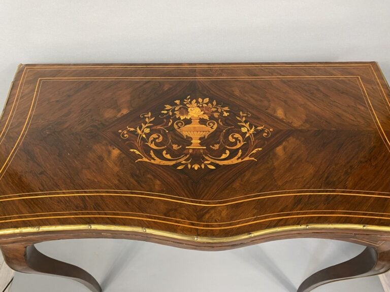Table à jeux de forme mouvementée en placage de palissandre à décor marqueté de…
