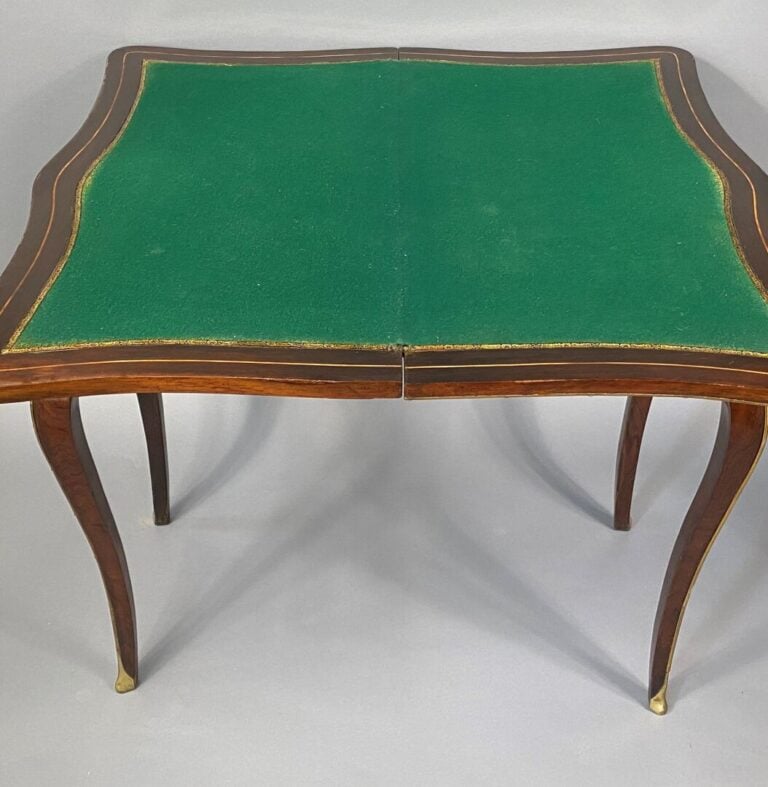 Table à jeux de forme mouvementée en placage de palissandre à décor marqueté de…