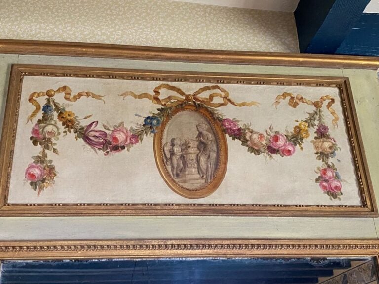 Trumeau en bois laqué crème, à décor dans un médaillon d'un sacrifice à l'amour…