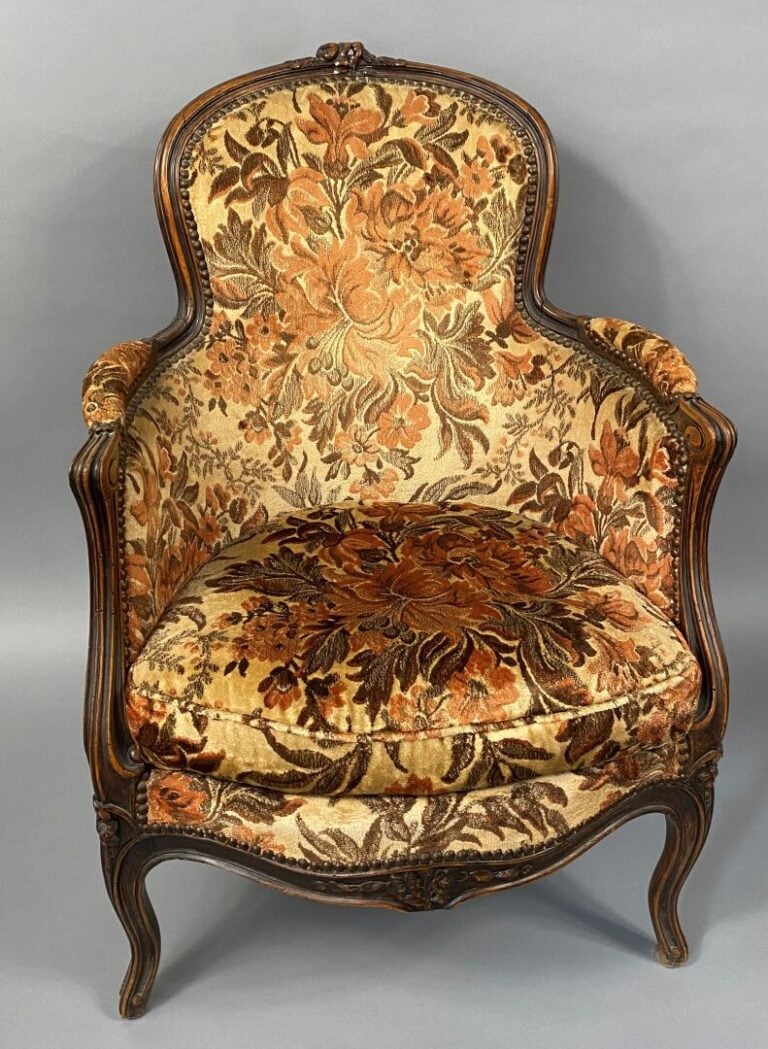 Une bergère à oreilles en bois mouluré et sculpté, pieds fuselés et cannelés, a…