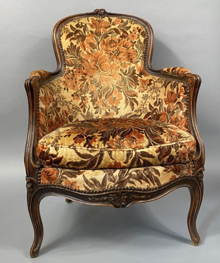 Une bergère à oreilles en bois mouluré et sculpté, pieds fuselés et cannelés, a…