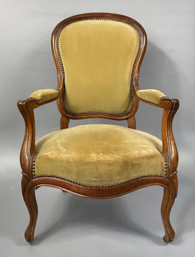 Une bergère à oreilles en bois mouluré et sculpté, pieds fuselés et cannelés, a…