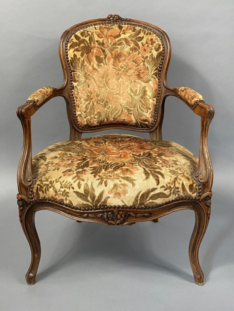 Une bergère à oreilles en bois mouluré et sculpté, pieds fuselés et cannelés, a…