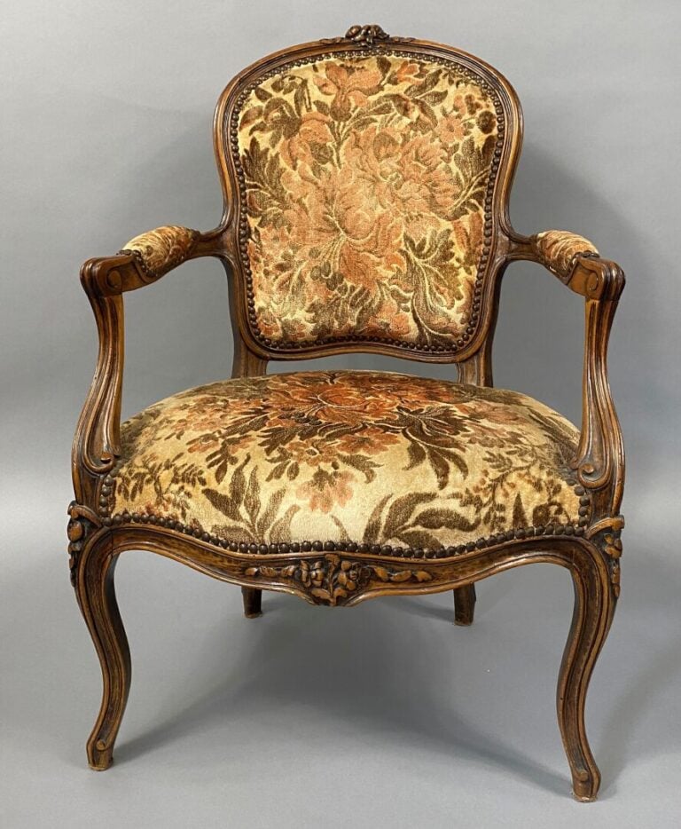 Une bergère à oreilles en bois mouluré et sculpté, pieds fuselés et cannelés, a…