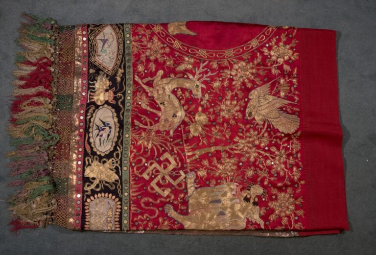 Une large broderie chinoise sur fond rouge à décor de calligraphies et chimères…