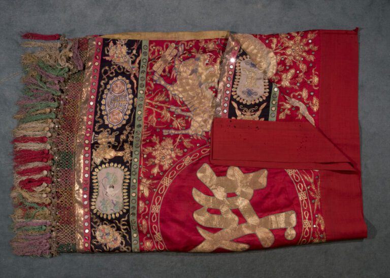 Une large broderie chinoise sur fond rouge à décor de calligraphies et chimères…