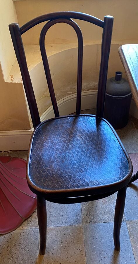 Une table de bistrot à piétement en bronze de fer et quatre chaises en bois cou…