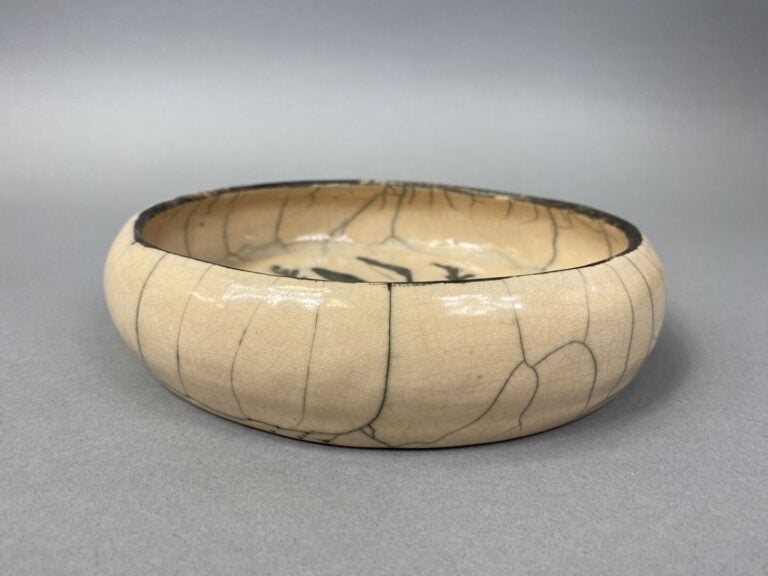 VALLAURIS ? - Plat en céramique émaillée à décor de végétaux sur fond beige cra…