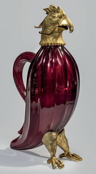 Aiguière à anse en forme d'aigle en verre rouge moulé à côtes, pattes et tête en bronze formant couvercle à charnièr