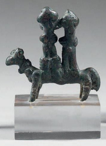 Amulette en forme de couple assis en amazone sur un cheva