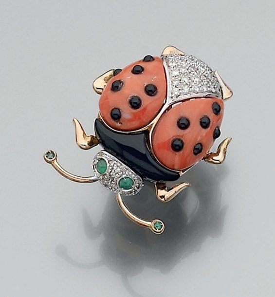 Amusante BAGUE « coccinelle » en or jaune et or gris 14 carats, partiellement articulés, sertis d'onyx, de corail, d'un pavage de diamants et de quatre émeraudes, dont deux cabocho