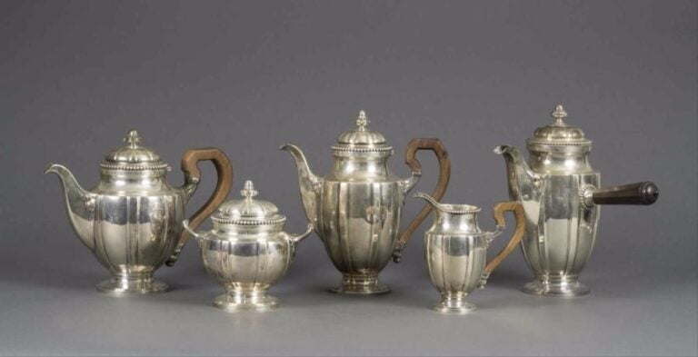 ARGENT Service cinq pièces en argent composé d'une verseuse, une chocolatière, une théière, un pot à lait et un sucrier à décor d'une frise de perles sur le couvercle, petit décor de feuillage sur le bec et les anse