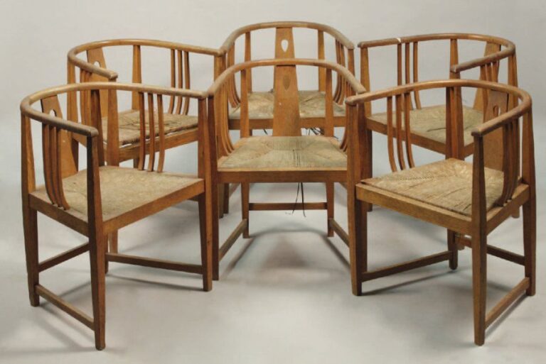 ART NOUVEAU Suite de six fauteuils en chêne ciré à dossier arrondi formant accotoirs à bandeau ajouré et barres latérale