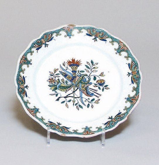 Assiette à bord contourné, décor polychrome dit « au carquois », guirlande de croisillons fleuris sur le bor
