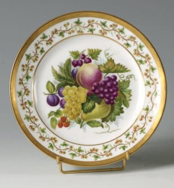 Assiette à décor polychrome au centre d'un bouquet de fruits et feuillages et sur l'aile d'une guirlande de fleur