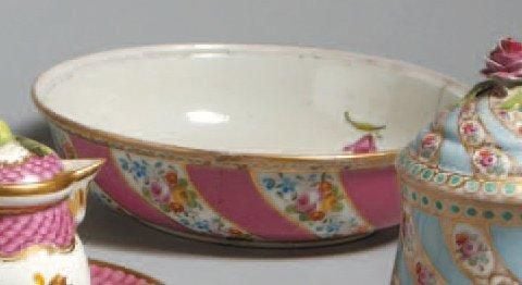 ASSIETTE Assiette creuse en porcelaine blanche, décorée de motifs floraux polychromes et de bandes obliques rose